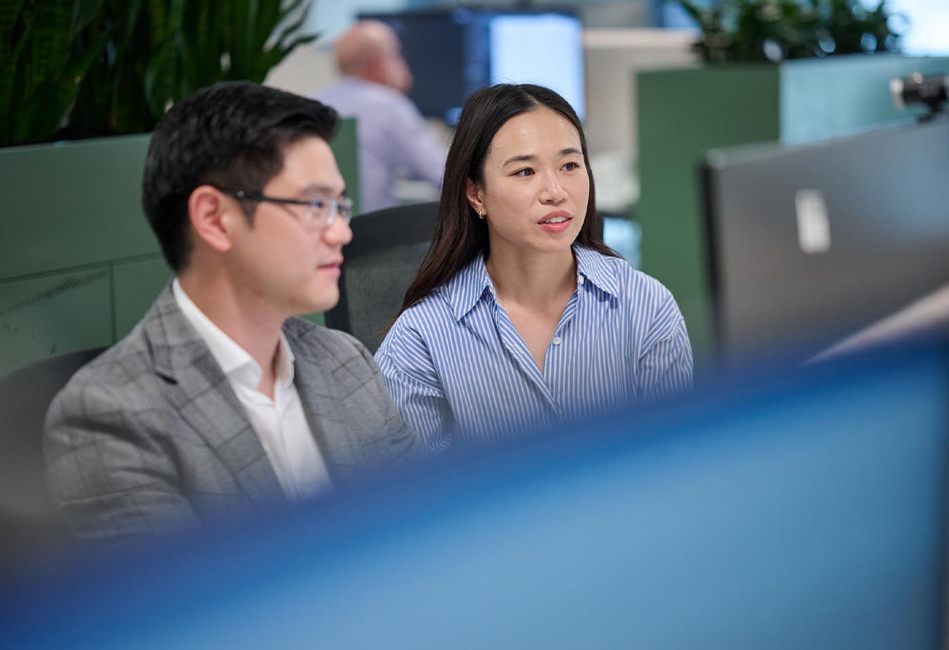 Two people seated side by side in an office setting.