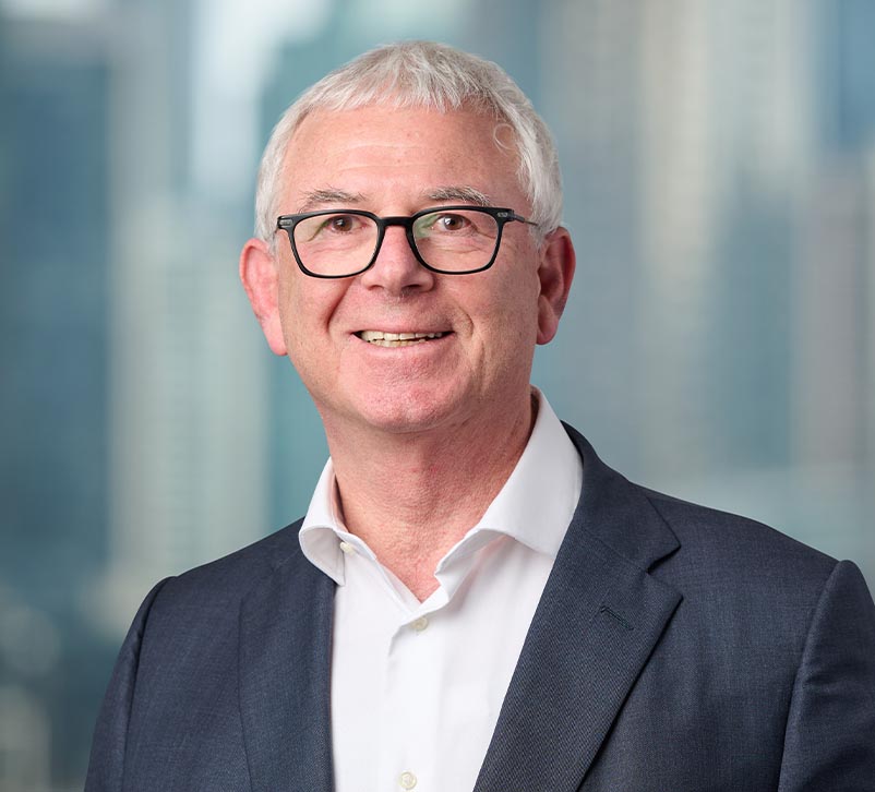 A professional portrait of Mr Michael Wachtel with a blurred city background.