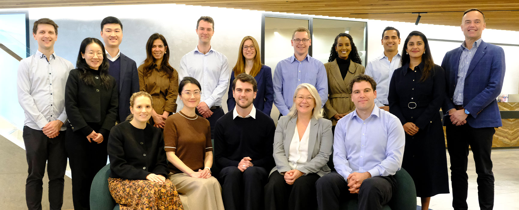 Group photo of sixteen of our people who have received promotions arranged in two rows, with some seated and others standing.